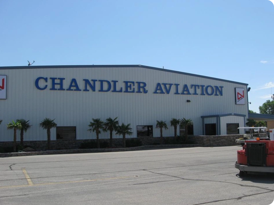 A large hangar with the name of chandler aviation on it.