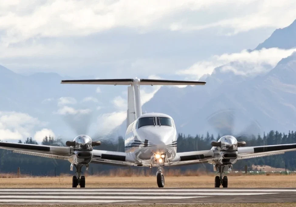 A small plane is on the runway of an airport.