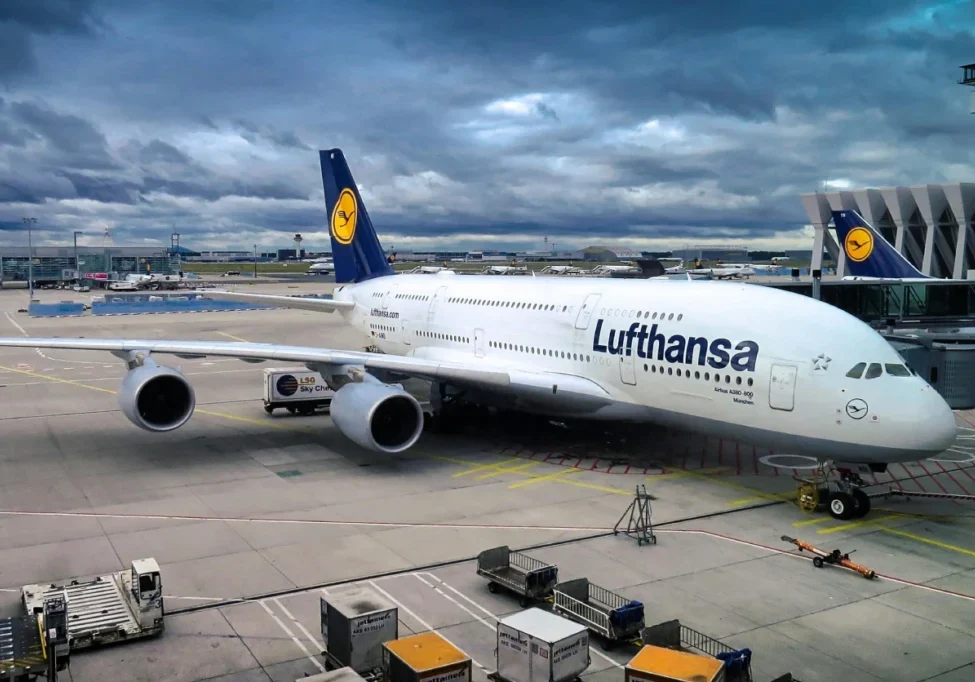 A lufthansa airplane parked at an airport terminal.